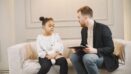 Bambina in seduta con psicologo infantile in stanza accogliente | psicologo per bambini